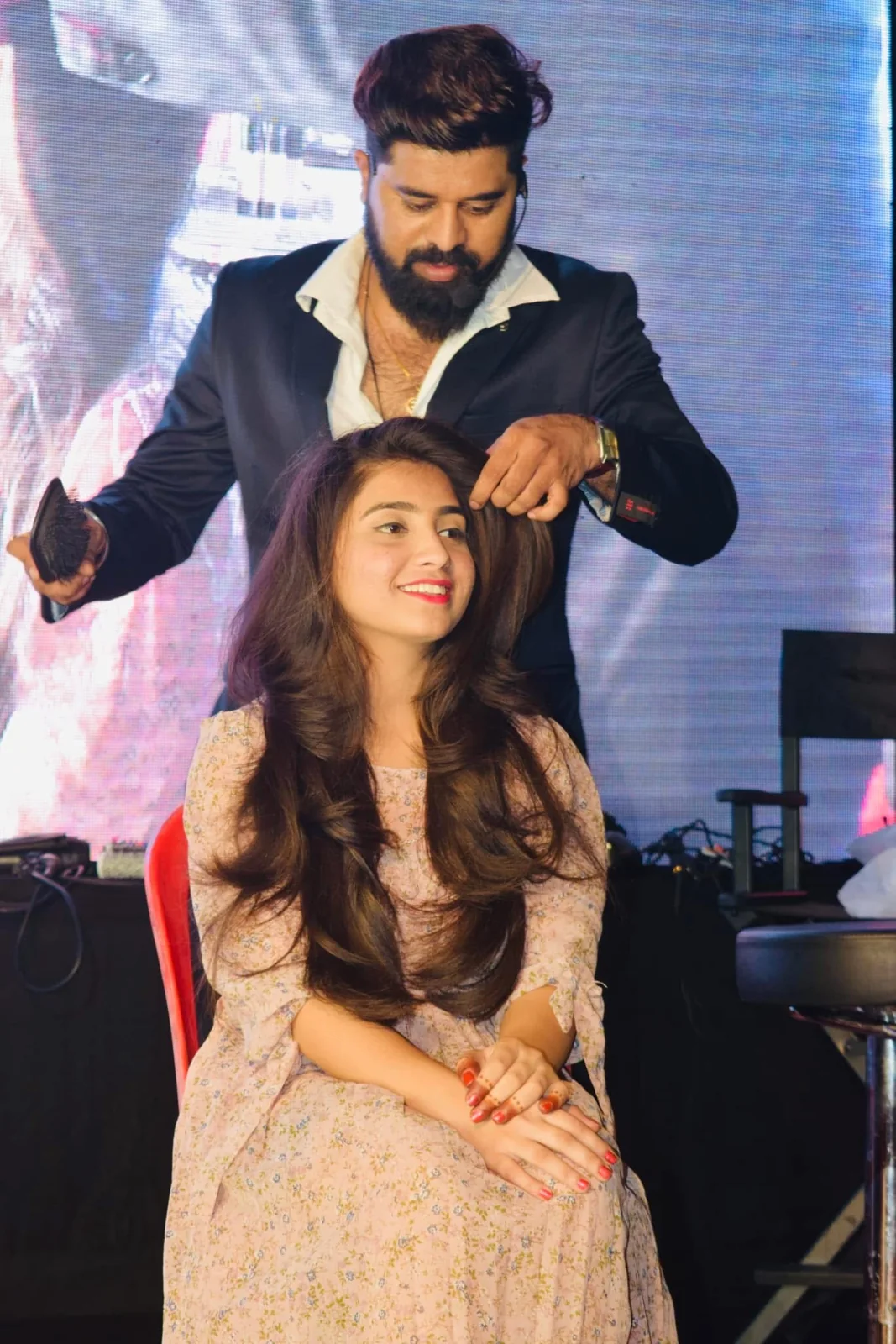 Bhavesh Bidve, Creative Head of The 7S Saloon, styling hair on stage in Sangamner